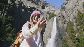 Yosemite National park wanderlust trip 6K USA. Young smiling woman on nature adventure. Beautiful traveller or travel blogger in beautiful mountain valley with waterfall making photos for social media - Powered by Shutterstock - Get 15% off with code: PIKWIZARD15