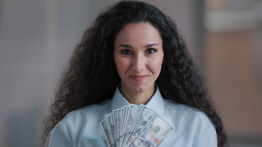 Amazed arabian business woman executive worker curly female investor rejoice getting real payment dollars currency win lottery cash prize profit receiving money bonus work salary surprised wow effect | Shutterstock HD Video #1089527403
