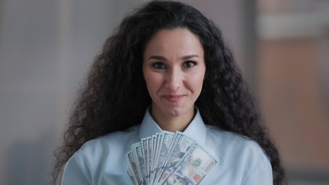 Amazed arabian business woman executive worker curly female investor rejoice getting real payment dollars currency win lottery cash prize profit receiving money bonus work salary surprised wow effect