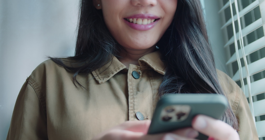 Close up Asian women are smiling and enjoying using their phones for online communication.Ordering and shopping online.Modern wireless tech user concept.