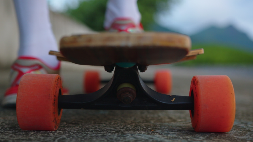Long board close-up. Legs of a teenager close up on a skateboard