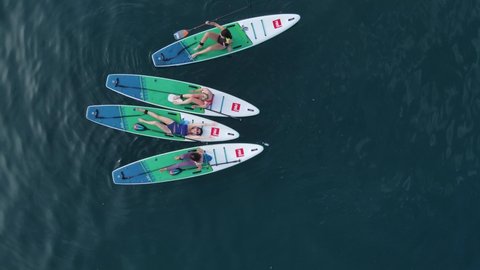 April 21, 2022. Sozopol, Bulgaria. Group of woman on stand up paddle board at sea. Relax on Red Paddle sup board in sea. Aerial view