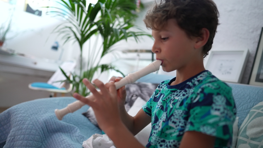 Kid playing flute young boy plays musical instrument