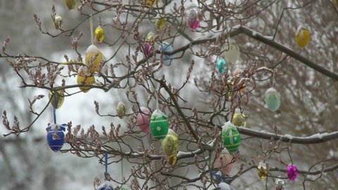 Colorful Easter Eggs And Titmouse On The Tree In The Garden. Snowy Spring In Germany. Festive Background.