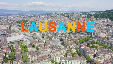 Inscription on video. Lausanne, Switzerland. Flight over the central part of the city. Different colors letters appears behind small squares, Aerial View, Departure of the camera