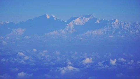 Close up view of epic aerial view of the Himalaya Mountain range with Everest mountain with snow and blue sky. Panorama shot from the aeroplane in winter. High quality 4k video.