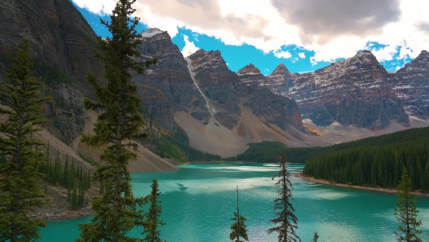 Pan right of Moraine Lake in Banff National Park, Canada, with snow-covered peaks of canadian Rocky Mountains in the background.. 4K UHD video. Royalty-Free Stock Footage #1089556725