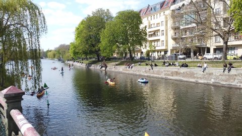 Berlin, Germany - April, 2022: Kayak and paddle boats on canal and people enjoying spring time near canal in Berlin
