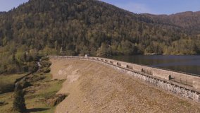 Aerial video from Alfeld Lake with its pure water surrounded by beautiful nature of Vosges Natural Regional Park in the heart of mountains during spring season. Located in France.