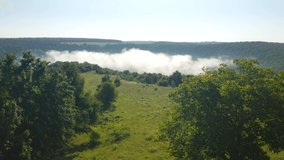 In the morning a thick white fog spreads through the valley. Footage from a bird's eye view. Location place Dniester canyon, Ukraine, Europe. Cinematic drone shot. Filmed UHD 4k video. Beauty earth.