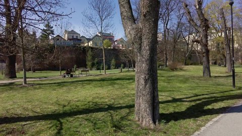 Sileuty of a couple sitting on a park bench on a spring sunny day, in the background the city walls and buildings of Olomouc, Czech Republic