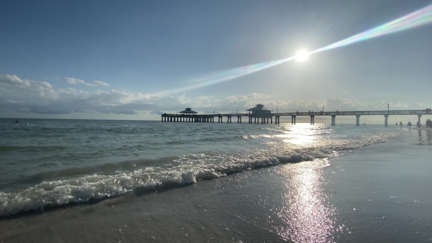 Waves rolling at Fort Myers Beach Pier, sun on a clearday at the beach