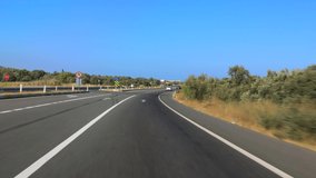 The car drives along the road on a sunny summer day. Highways, roadside and road line markings.
