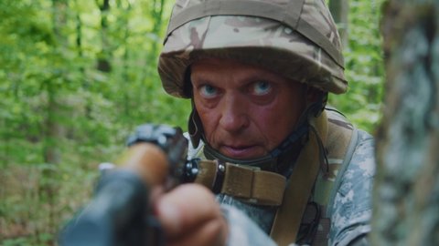 Portrait man soldiers with helmet and uniform holding machine gun forward to attack enemy in forest. Machine gun barrel look at camera