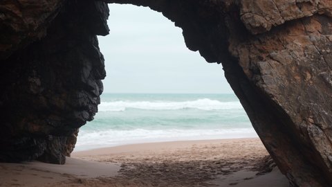 Ocean wild beach stormy weather. Gate on the Praia da Adraga beach, a North Atlantic beach in Portugal, Sintra Cascais, Portugal Handheld effect. 