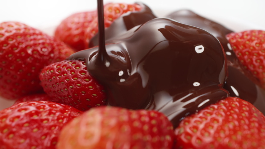 Close-up macro fresh strawberries covering with melted liquid chocolate. Molten chocolate or brown caramel stream pouring on juicy red berries. Confectionery, tasty dessert. Cooking handmade sweets | Shutterstock HD Video #1089575893