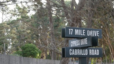 Scenic 17-mile drive wooden road sign, Monterey peninsula, Big Sur, California, USA. Coastal roadtrip, cypress forest. Pacific coast highway tourist route. Hitchhiking trip, ecotourism on vacations.