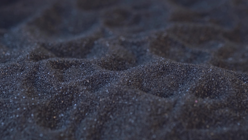 The miners are placing the gold ore found in the mine on the black sand.