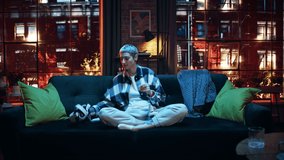 Cinematic Portrait of a Young Stylish Female with Short Hair Putting On Virtual Reality Headset. Creative Woman Sitting on a Sofa at Home in the Evening, Playing VR Video Games. Dramatic Zoom In Shot - Powered by Shutterstock - Get 15% off with code: PIKWIZARD15