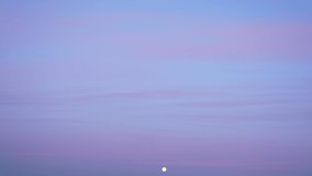 4k video time lapse of full moon rising up in clear blue sky in evening. Dramatic scenic sunset time. Pastel pink and violet clouds isolaetd on clear blue sky background texture - Powered by Shutterstock - Get 15% off with code: PIKWIZARD15