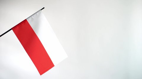 State flag of Republic of Poland waving on light background. Polish flag and place for text
