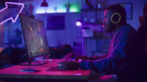 Professional eSports Gamer Winning Online Tournament. RPG Strategy Video Game with Lots of Action and Fun on His Powerful Personal Computer at Home. Cyber Gaming Stylish Retro Neon Room.