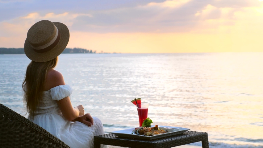 Female tourist eat food, look at beautiful view of sea, enjoy her holidays. Luxury travel woman on summer vacation. Fine seafood dinner or supper table served in resort restaurant on beach near ocean. | Shutterstock HD Video #1089584155
