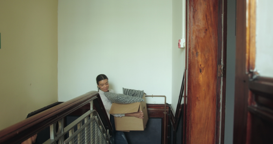 Asian Adult Male Moving into New Home Carrying Cardboard Boxes up Staircase