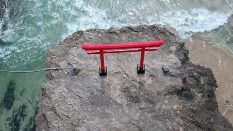 Red Torii Gate On The Rock Overlooking Beautiful Beach Of Shirahama In Shimoda, Japan. aerial drone top-down