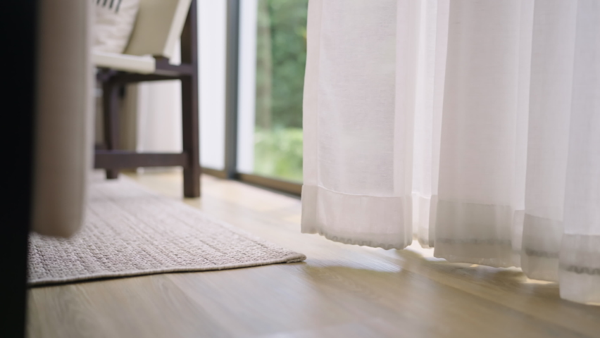 Close up white sheer curtain with sun light with shadow shade on wooden floor home interior design concept,cozy home morning light with sun through white curtain window peaceful and clam moment | Shutterstock HD Video #1089589813