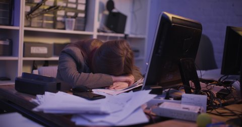A young woman fell asleep at the table in the office, then she wakes up and stands on the phone. Slow motion 4k footage