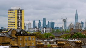 London, UK. Aerial view of a residential district with modern skyscrapers in the background in London, UK. Heavy clouds over the city. Time-lapse at day, panning video