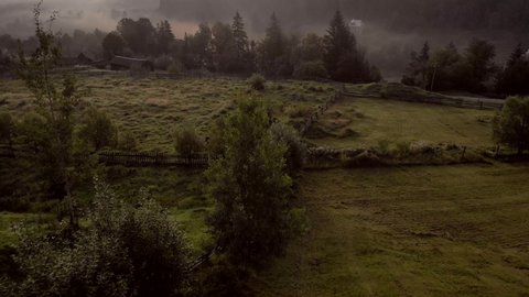 Early morning with fog in alpine village. Foggy morning panorama of mountains valley. Beauty of nature concept.