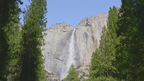 Cinematic dolly slow motion shot of Yosemite valley with the highest waterfall in Northern America, world famous National park in California USA. Scenic beautiful clear water from melting ice glaciers