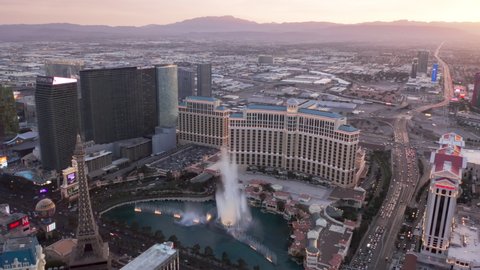 Las Vegas Strip Nevada, USA April 2022. Twilight high angle view of Strip cityscape with cinematic rose pink sunset view. Scenic Bellagio fountains show illuminated in dusk under pink sky over horizon