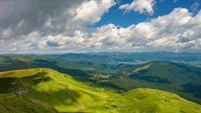 Quick motion of fluffy cumulus clouds over mountain valley at sunny summer day. Popular Drahobrat ski and hiking resort in Carpathian Mountains, Ukraine. 4K Time Lapse