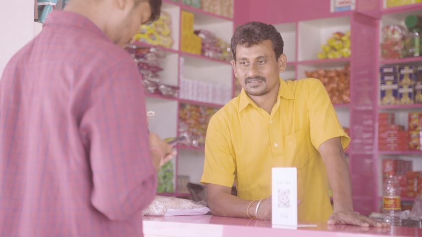 handheld shot of customer paying money after trying to pay not working using QR code scanner at kirana store - concept of technical or internet issue during payement. Royalty-Free Stock Footage #1089614089