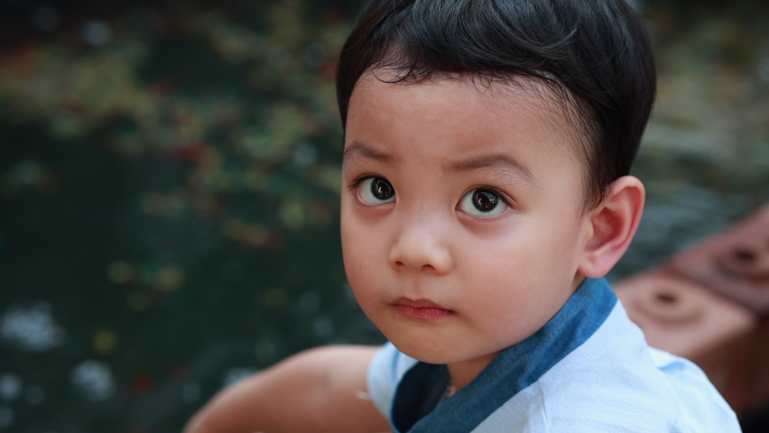 Asia kid playing in the koi fish farm