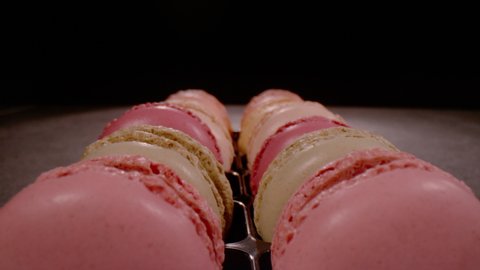 SUPER SLOW MOTION, CLOSE UP, PROBE LENS: Close up overview of sweet macarons in pastel colours in slow motion. Pull back shot of lined up French confectionery. Detailed view of delicious temptation.