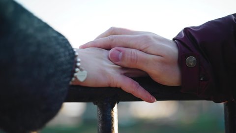 A man strokes his woman's hand trying to warm it. Close-up shooting of hands