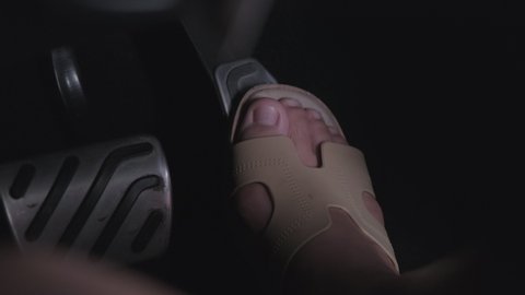 Close-up of feet on the accelerator pedal and brake pedal in a car. The driver drives the car by pressing the accelerator pedal of the car. inside vehicle.