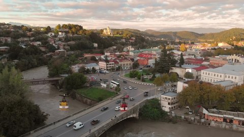 Aerial view of Kutaisi cityscape at sunset in Georgia. Drone footage of the Kutaisi city center, old cable car road over the Rioni river and Bagrati Cathedral church