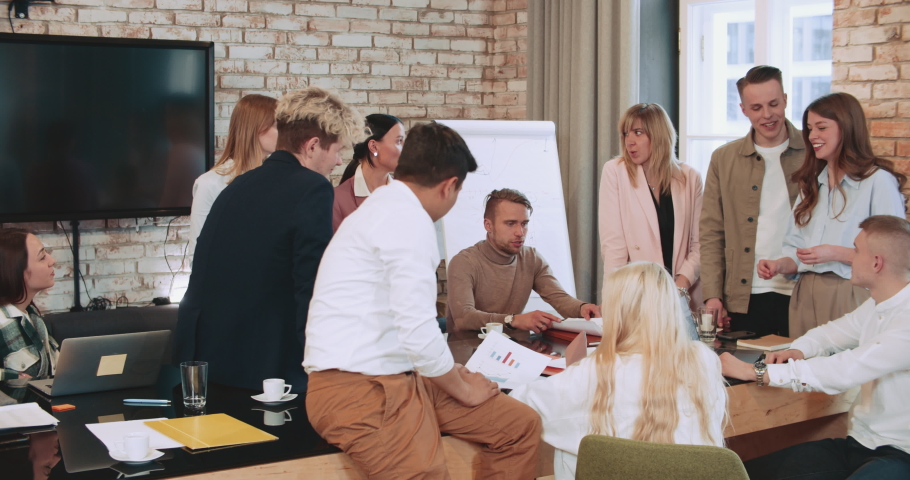 Group of young diverse business people working together generating ideas at modern creative work hub office slow motion.