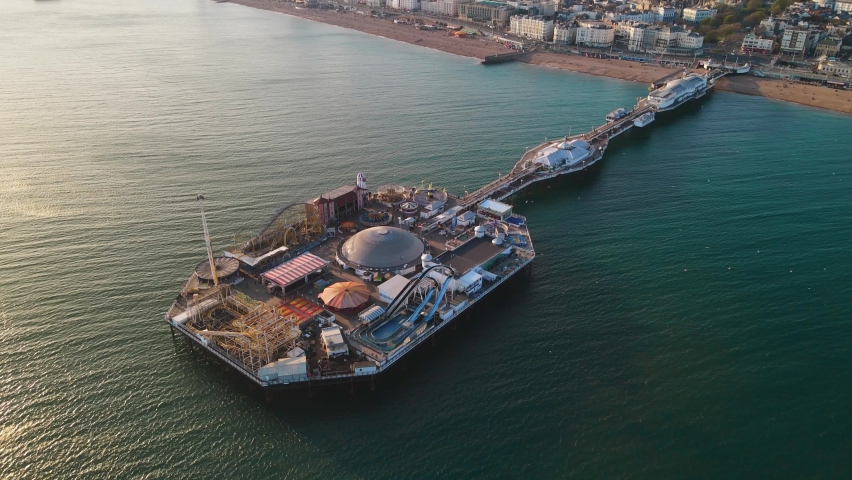 Drone shot of Brighton Palace Pier, with the seafront behind. Aerial shot of the stunning city of Brighton and Hove with seagulls flying around Royalty-Free Stock Footage #1089626321