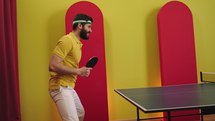 Attractive man catch the balls on the ping pong game and getting excited that he win the guy are full equipment in the uniform concept of sport and healthy lifestyle