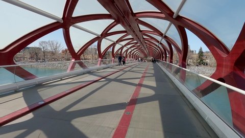 Calgary, Alberta - April 24, 2022: Pedestrians enjoying Calgary's landmark footbridge in downtown path system. 