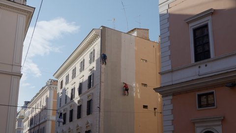Climbers workers restoring the facade of an historical building in Rome (Italy)