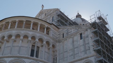 Construction workers working on high scaffold during facade renovations of a church in Pisa (Ialy)