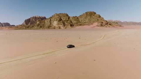 Car Exploring In Wilderness At Wadi Rum Desert In Jordan. Aerial Wide Shot