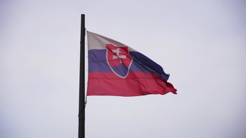 Slovakia flag in wind waving on flagpole, close up view of real textile symbol of Slovakia